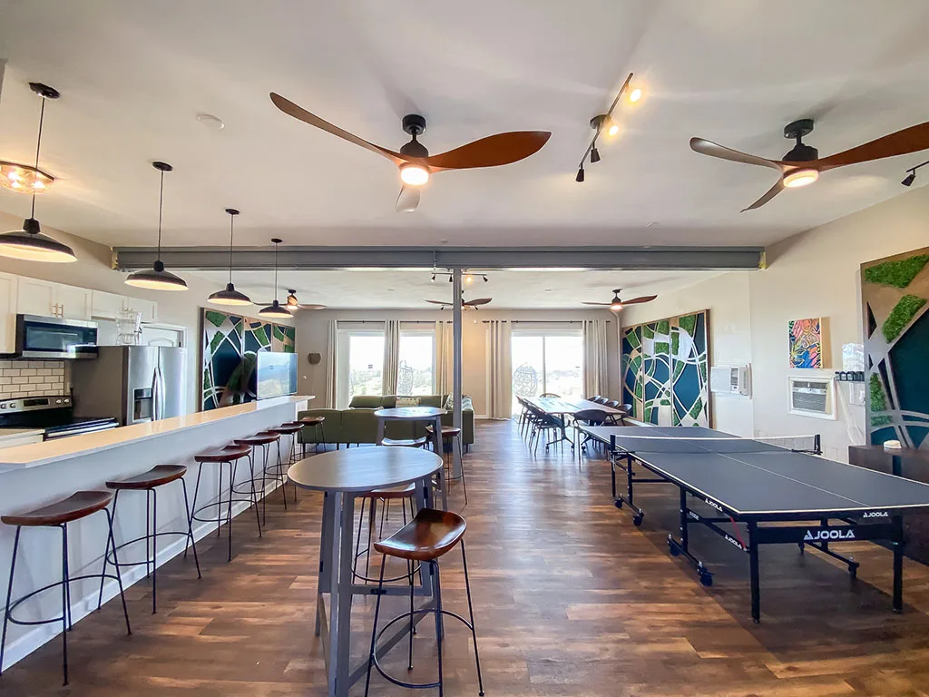 Our standout feature is the spacious entertaining room, complete with a full kitchen, multiple large dining tables, cocktail tables, and a game room.